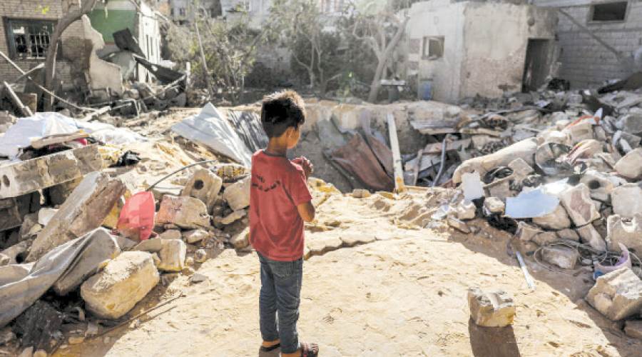 طفل فلسطينى يقف على أنقاض منزله فى غزة